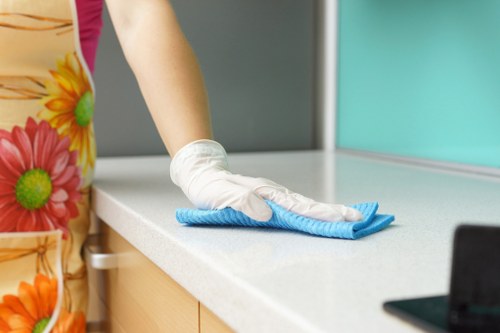 Cleaner tidying desks and shared office spaces in Sutton